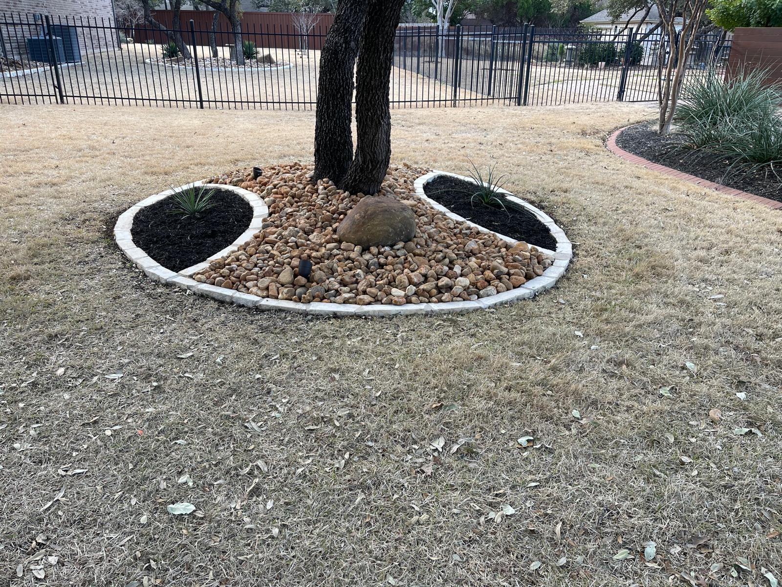 Clean tree ring with stone border after yard cleanup